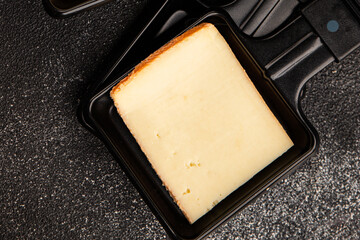 Raclette cheese portion slicing natural product tasty snack fresh delicious gourmet food background on the table rustic top view copy space
