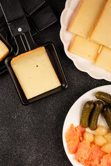 Raclette cheese portion slicing natural product tasty snack fresh delicious gourmet food background on the table rustic top view copy space
