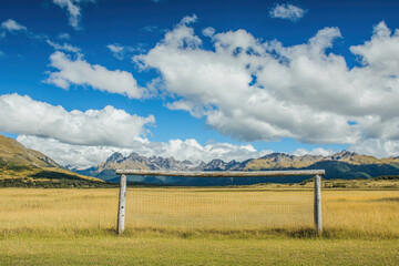 Fototapeta premium Scenic soccer goal on a meadow with majestic mountains and a picturesque blue sky, symbolizing freedom and excitement