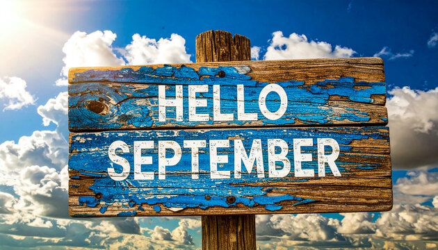 Weathered Hello September sign against bright sky