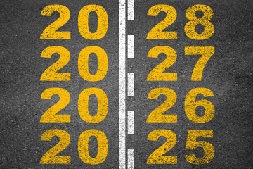Fototapeta premium Black asphalt road with new year numbers 2025, 2026, 2027, and 2028. New Year and new business goals and targets.