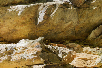 Closeup of layered rock formation with cracks and natural texture in sunlight