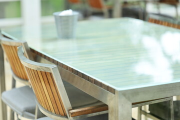 A modern setting featuring a glass table with chairs and a decorative vase