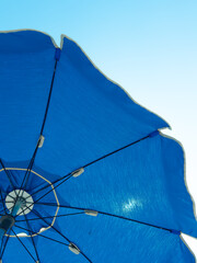 Low angle view of a blue beach umbrella with blue sky 