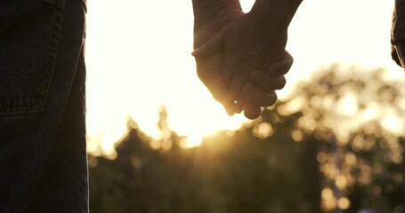 Close-up of a couple holding hands during sunset in a park. Romantic moment, love, trust, intimacy, and emotional connection. Perfect for illustrating relationships and harmony. Happy man and woman - Powered by Adobe