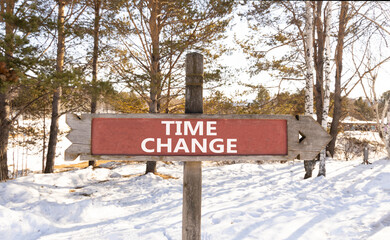 Time change symbol. Concept word Time change on beautiful wooden road sign. Beautiful snow winter forest background. Business time change concept. Copy space.