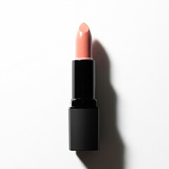 Obraz premium lipstick isolated on white background. Nude pink lipstick in a black tube lying horizontally on a white background.