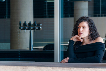 Woman waiting thoughtfully at outdoor bar