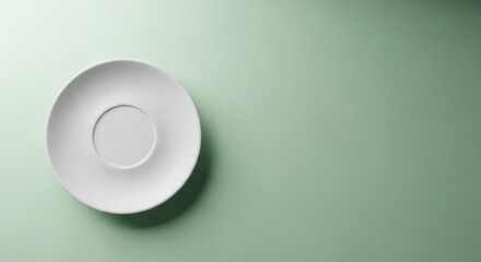 Minimalist white saucer on pastel green background for elegant table setting