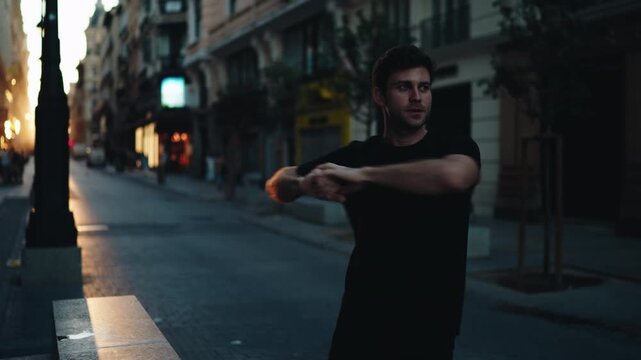 Man stretching arms on city street at sunrise, preparing for workout. Represents discipline, motivation, and morning fitness routine with focus on wellness and balance.
