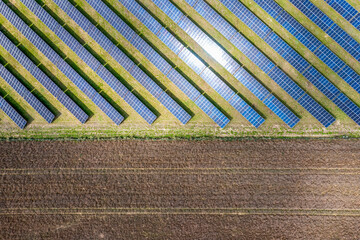 Photovoltaic farm. Photovoltaic panels in a field, view from a drone.