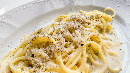 Creamy linguine twirls embrace freshly grated pecorino, evoking La Dolce Vita and National Spaghetti Day indulgence