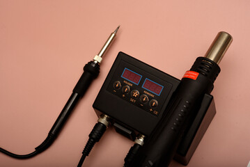 Black soldering station with hairdryer and soldering iron.