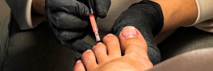 Intricate pedicure artistry unfolds as hands meticulously paint nails, embodying the serenity of...