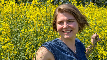 A smiling Caucasian woman basks in golden canola fields, reminiscent of Solstice Sun Rituals and...