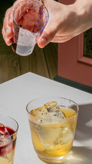 Effervescent mixologist's hand crafting a twilight cocktail, evoking National Cocktail Day's...