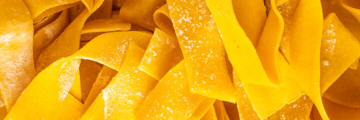 Golden ribbons of uncooked egg pasta resemble sunlit harvest sheaves, evoking Italian Nonna's Sunday feast and La Festa della Pasta