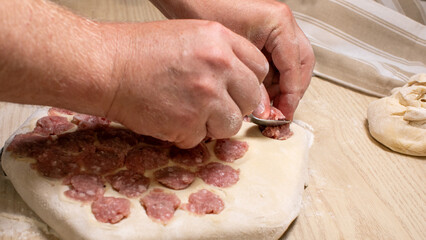 A bakers hands deftly craft Italian salami crescent rolls, evoking Sagra del Belbo warmth and artisanal heritage whispers