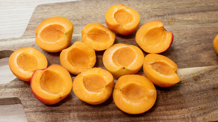 Sliced apricots rest whimsically on rustic wood, embodying Midsummer's nectarous bounty, perfect for culinary solstice celebrations or apricot appreciation day