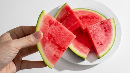 Juicy watermelon slices, vibrant splash of summer delight, Ethnic American male hand, refreshing National Watermelon Day celebration vibes