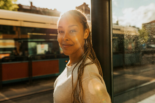 Sunlight shining on smiling beautiful young woman with braided hair