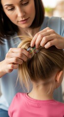 Naklejka premium A woman styles a young girl's hair, using colorful hair ties to create a neat ponytail, showcasing a nurturing and creative moment between them.