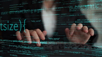 Close-up of hands typing on a keyboard with colorful programming code displayed in the background, representing modern technology and software development activities. Xenic