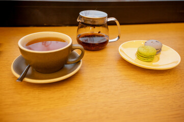 A cozy setting with a charming cup of tea and colorful macarons on a chic table