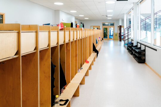 Empty corridor with wooden lockers in rows at elementary school