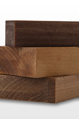 Three pieces of wood exhibiting distinct shades and grain patterns are stacked on a light background, ideal for crafting and design purposes in woodworking.
