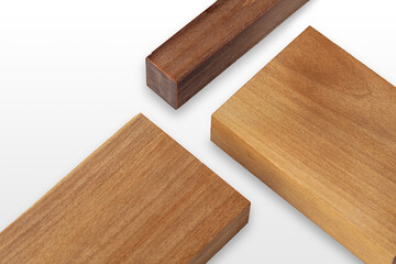 Three pieces of wood exhibiting distinct shades and grain patterns are stacked on a light background, ideal for crafting and design purposes in woodworking.
