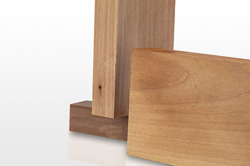 Three pieces of wood exhibiting distinct shades and grain patterns are stacked on a light background, ideal for crafting and design purposes in woodworking.
