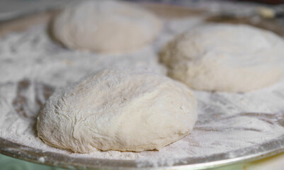 Kneaded dough resting on a floured surface in a baking kitchen