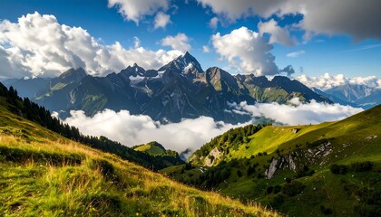 Obraz premium A breathtaking vista unfolds across a sun-drenched alpine landscape, showcasing rolling hills, lush greenery, and majestic mountain peaks cloaked in a layer of ethereal clouds.