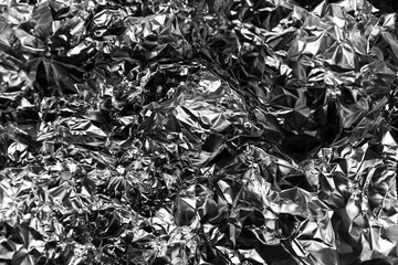 Shiny crumpled foil with metallic abstract look, futuristic texture, chrome surface and cyberpunk style reflective pattern.