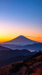 Fototapeta premium A breathtaking mountain vista at dawn, showcasing the majestic Fuji with colorful skies and vibrant autumn foliage.