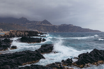 Obraz premium View from coast in Giardini Naxos in the Metropolitan City of Messina on the island of Sicily, Italy. Taormina city and Castelmola town on background