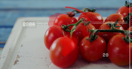 Showing vine tomatoes glistening with droplets on board with digital overlay, blue plank backdrop
