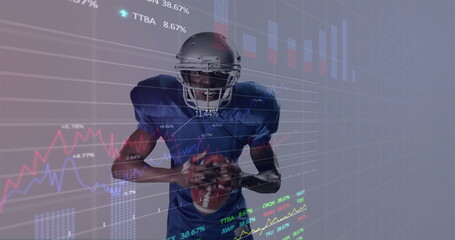 Standing player wearing helmet and blue jersey gripping football in studio, with financial charts