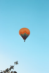  Hot air balloon flying in clear blue sky. Minimalistic travel and adventure concept.