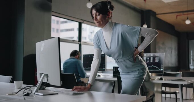 Business, group and woman with back pain at computer for bad posture, trading burnout or discomfort. Graphs, trader or tech with sore spine from medical injury, tension or coworking at brokerage firm