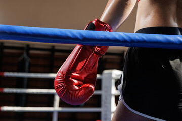 Red boxing glove on ring ropes during training