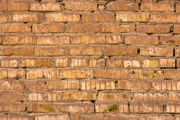 Obraz premium A detailed shot presents an old brick wall showcasing a weathered texture with visible signs of age and wear. The rustic masonry features cracked and uneven surfaces, with a palette of brown and