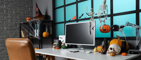 Interior of dark office decorated for Halloween with workplace and shelf unit