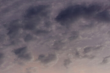 Stormy sky with thunderclouds and moon in the evening.