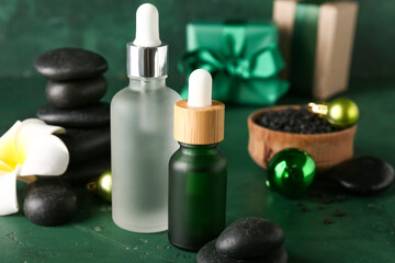 Bottles of essential oil, spa accessories, Christmas gifts and decorations on color background, closeup