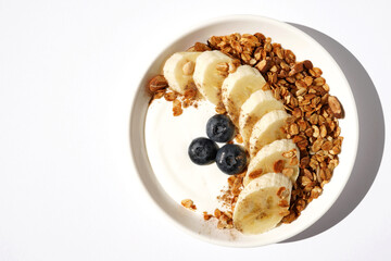 Natural Greek Yogurt with Homemade Granola, Banana Slices and Blueberries. Breakfast.