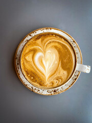 Close-up of a cappuccino with heart-shaped latte art on a gray table in a cozy cafe in Iceland