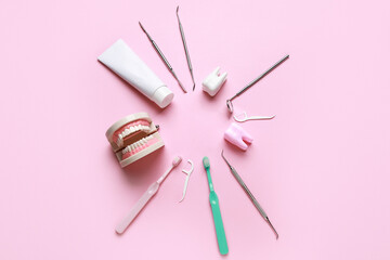 Frame made from dental tools, oral hygiene supplies and plastic models on pink background. World Dentist Day