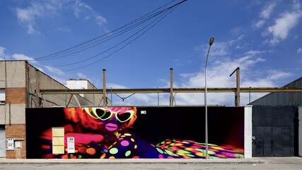 industrial complex with neon disco dancer overlayed on the wall